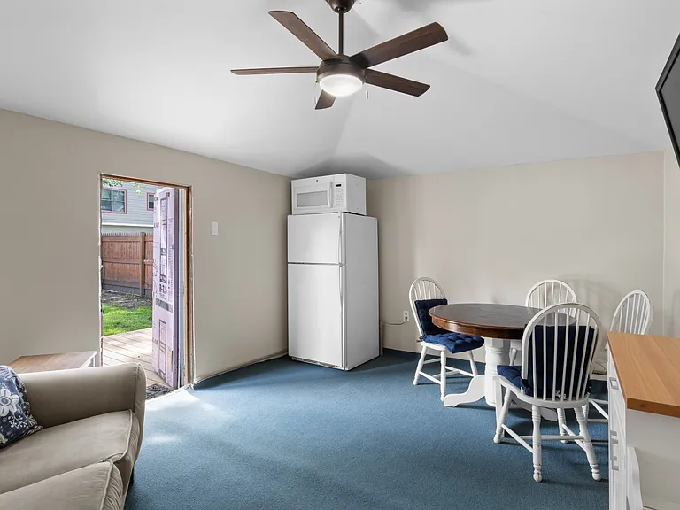 Outdoor den / recreation room with refrigerator, microwave and table