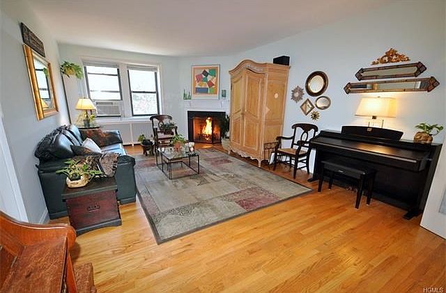 Large Sunny living room with working wood burning fireplace, refinished hardwood floors and French doors leading to the new kitchen with Granite Counters and Stainless Steel appliances.