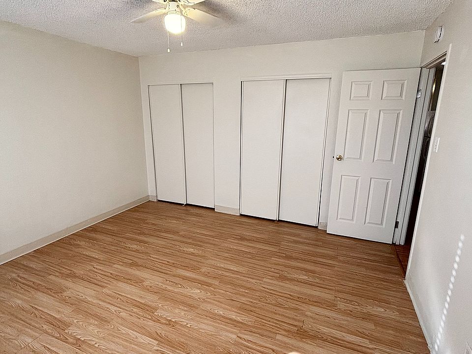 Bright and airy bedroom with elegant wooden flooring and ample closet space, perfect for a cozy living environment.
