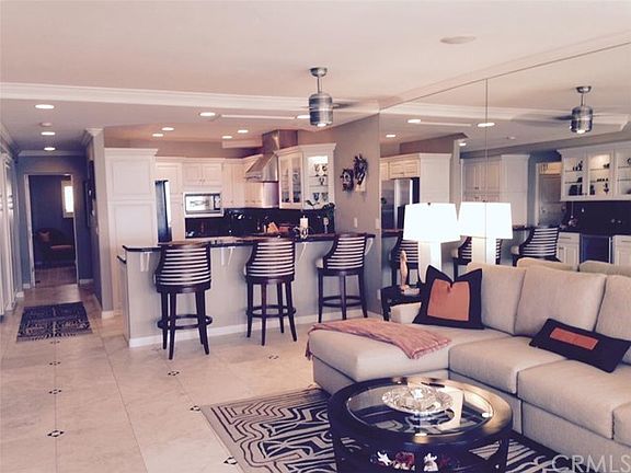 Living Room and Kitchen. Notice the travertine flooring, crown molding & recessed lighting.