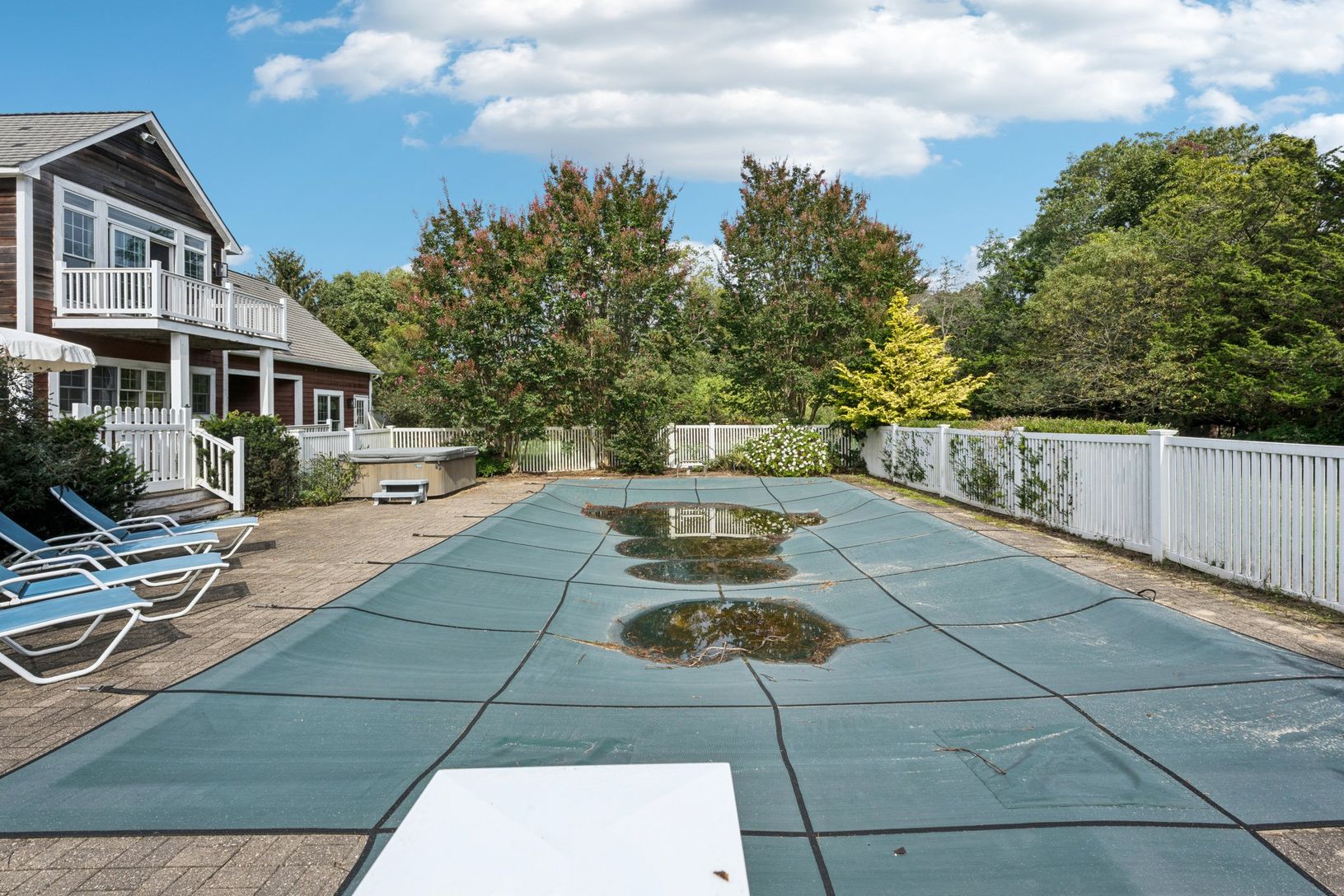 A picturesque view showcasing the swimming pool, sunlit patio, and hot tub.