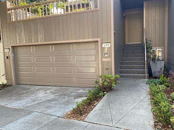 Street view, including 2 car garage with outdoor deck above garage