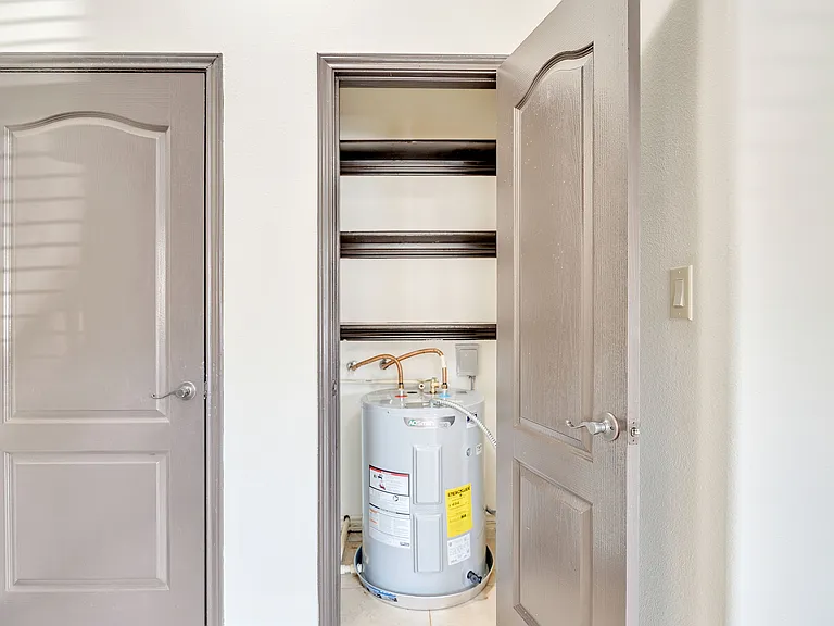 A corner of a room in Merida Vista Apartments features a water heater, highlighting the apartment's interior