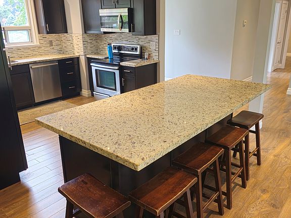 Kitchen is open to living room, entrances, and main floor hallway.