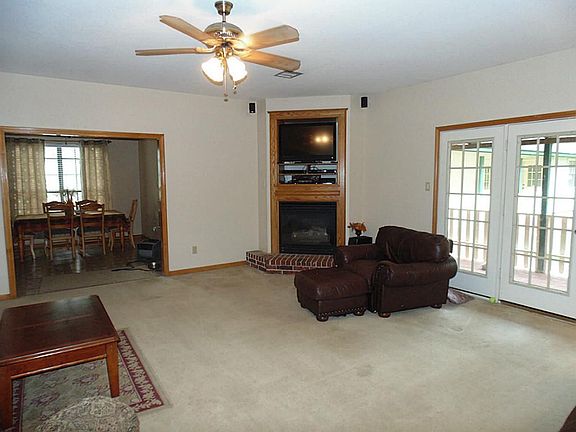Large living area with fireplace and French doors leading to covered porch.