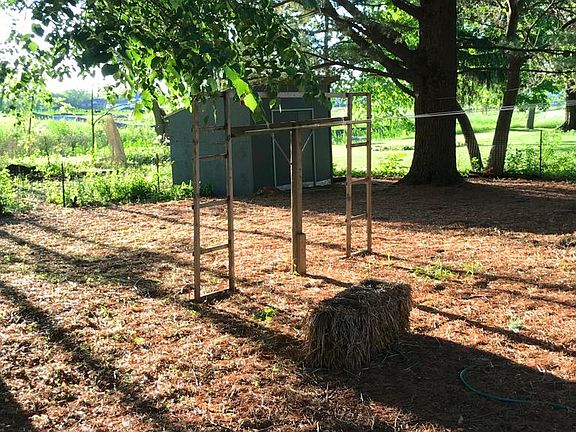 Half-shaded backyard with tool shed, laundry lines, central air conditioner