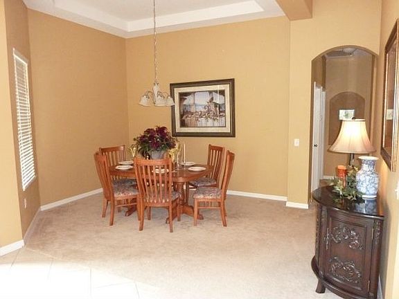 Spacious dining room with double tray ceilings and wooded views.