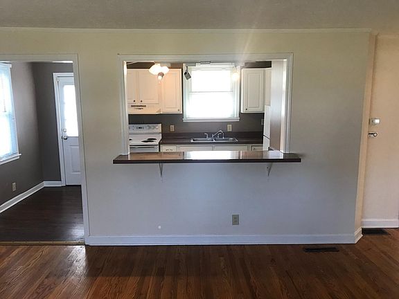 Living room with view into kitchen
