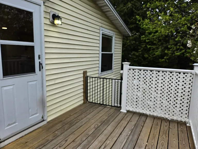 Medium sized Back deck entrance. Space to add a small patio set. In the summer, this space feels very private due to the leaves on the trees. The Pet gate can be removed by landlord upon request.