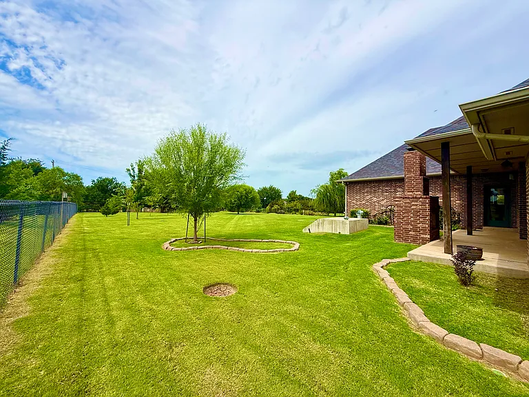 This is a view from another gate that is accessible on the west side of the house. This is the backyard and you can view the chain link fence that glides along the property line.