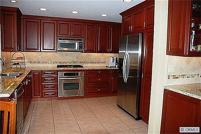 Gorgeous Kitchen with granite counters, cherry wood cabinetry, tile floors, an