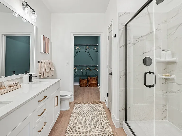 Bathroom with Quartz Countertops, Double Vanity Sinks, Walk-in Shower, and Walk-in Closet