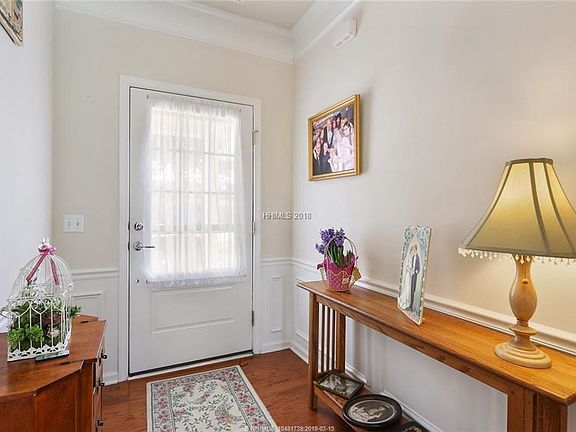 The foyer with chair molding and custom trimwork invites you into this lovely home.