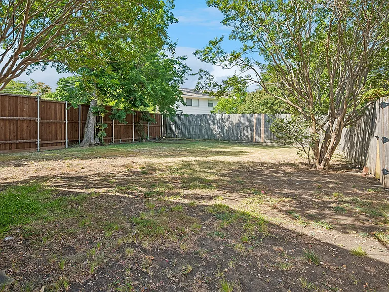 Large backyard with wood fence.