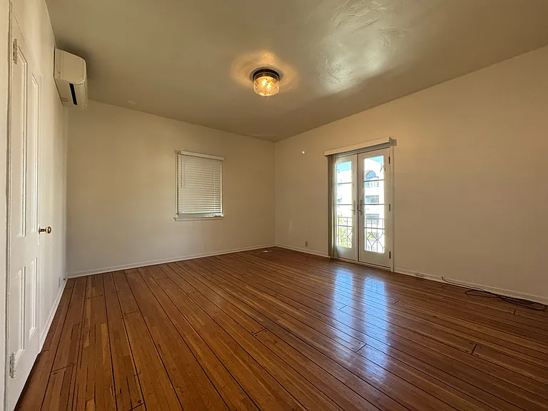 Second upstairs bedroom - mini-split AC, French doors to balcony, closet on the left.