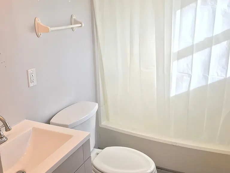 Newly updated bathroom with brand new vanity, mirror, flooring, and hand held shower head.
