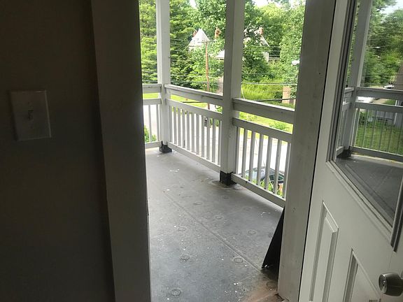 Covered porch overlooking the street, attached to kitchen and dining area. Set among the trees, enjoy the neighborhood!
