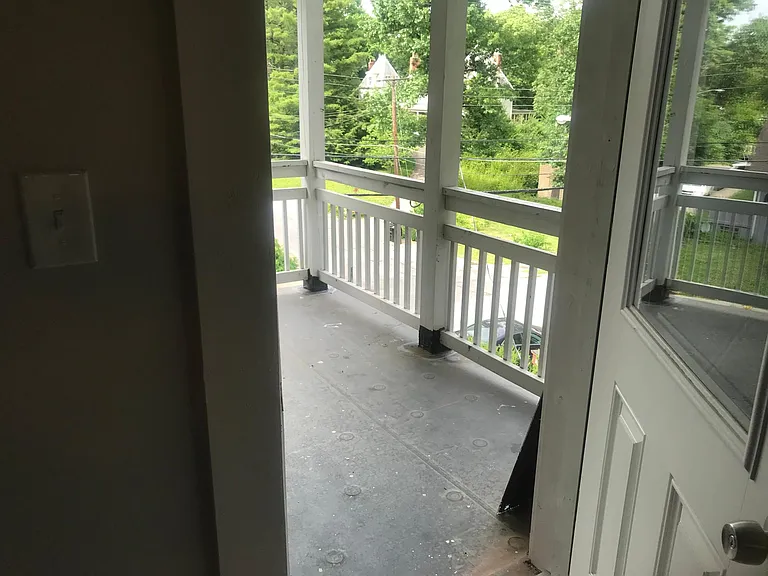Covered porch overlooking the street, attached to kitchen and dining area. Set among the trees, enjoy the neighborhood!