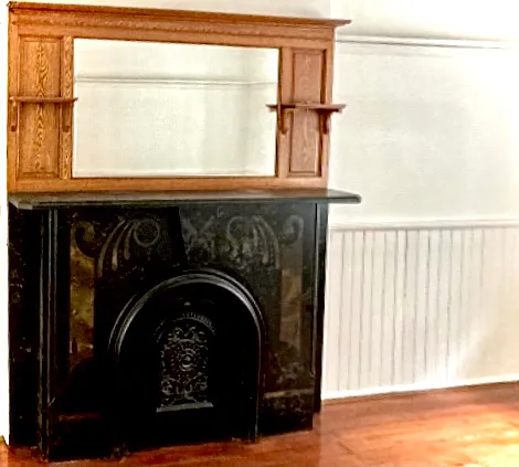 Original marbleized mantel with oak framed mirror above. Living room features original wainscoting, as well.