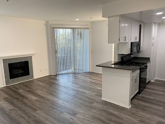 Light, bright living room and kitchen with recessed lighting. Small balcony off the living area.