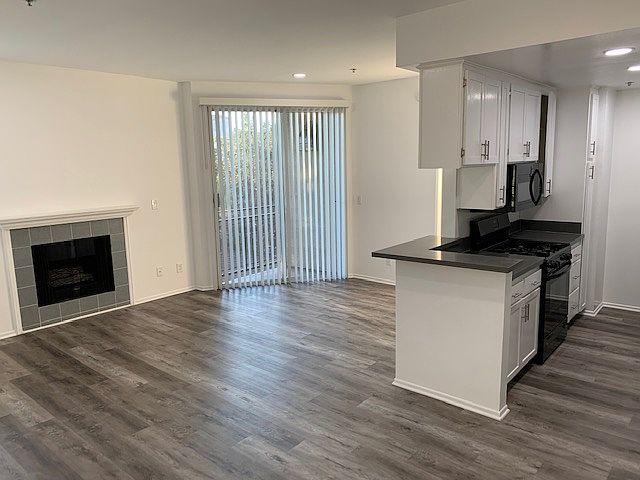 Light, bright living room and kitchen with recessed lighting. Small balcony off the living area.