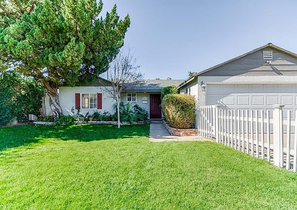 Front yard is enclosed with white picket fence.