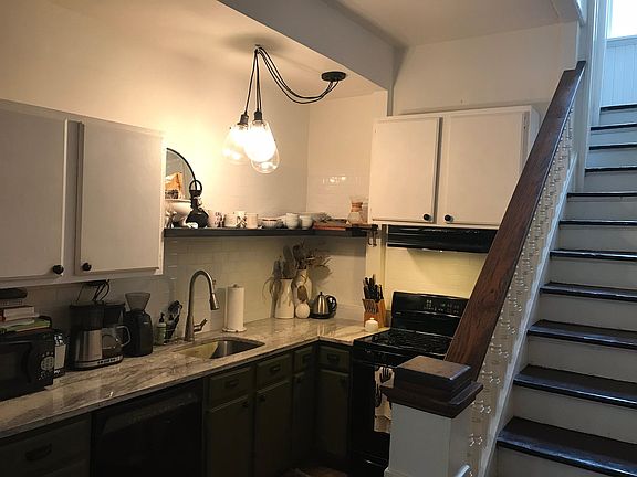 Kitchen updated 2019 with granite countertops, tile backsplash, new appliances, and modern light fixtures