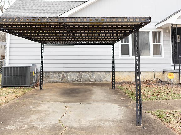 Exterior with covered entrance, separate driveway with covered parking