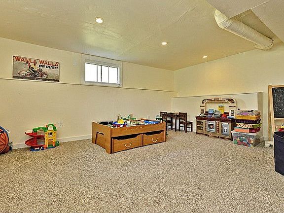 Large daylight basement family room, carpeted, bright play space. The lower level also offers a large storage area, updated mechanicals and garage access.