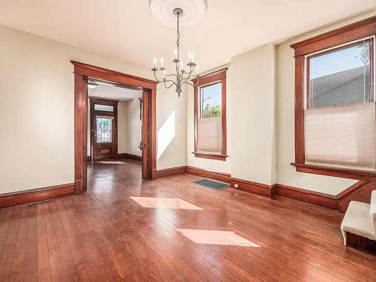 Dining room with chandelier lighting and original wood floors.