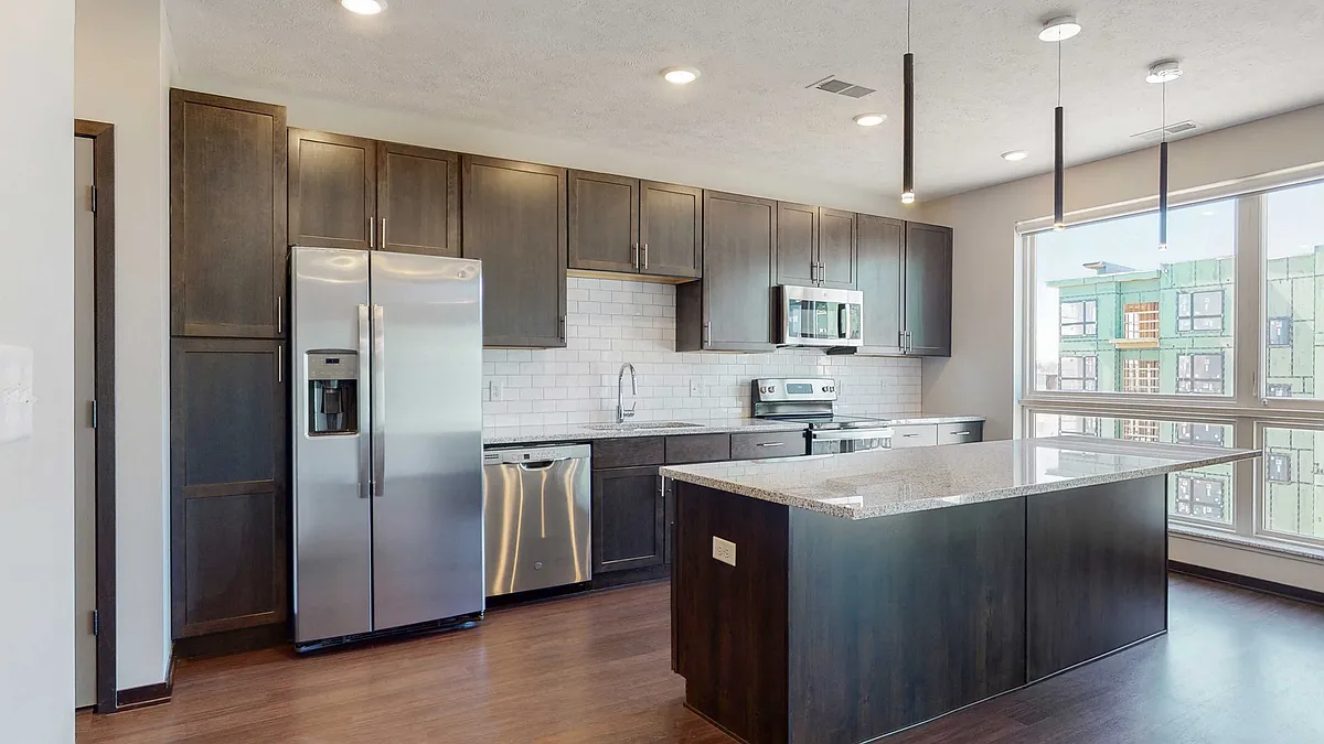 Our kitchens feature beautiful cabinetry, stainless steel appliances, and large islands, perfect for cooking and entertaining. - Haven at Uptown