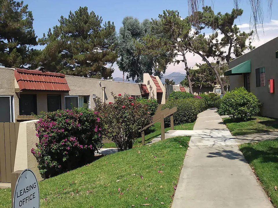 Beautifully landscaped walkways between buildings at Teton Pines Apartments in Escondido, California.