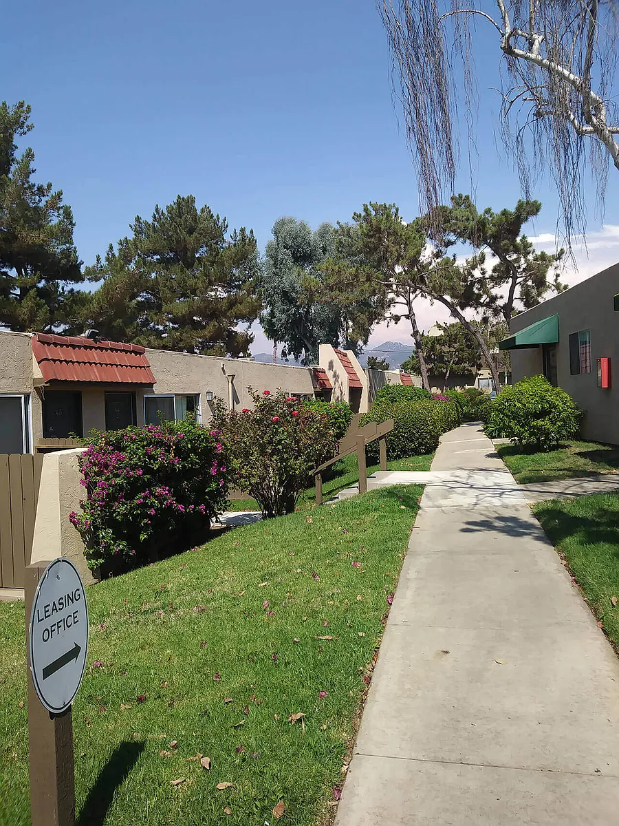 Beautifully landscaped walkways between buildings at Teton Pines Apartments in Escondido, California. - Teton Pines Apartments