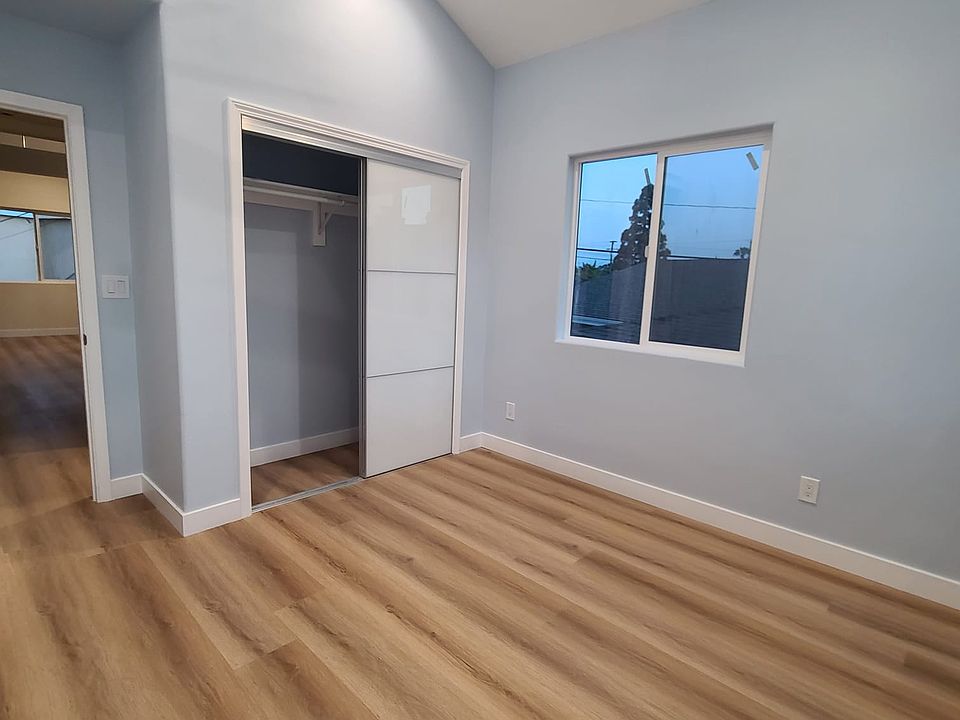 First bedroom with vaulted ceiling, closet, and bonus storage