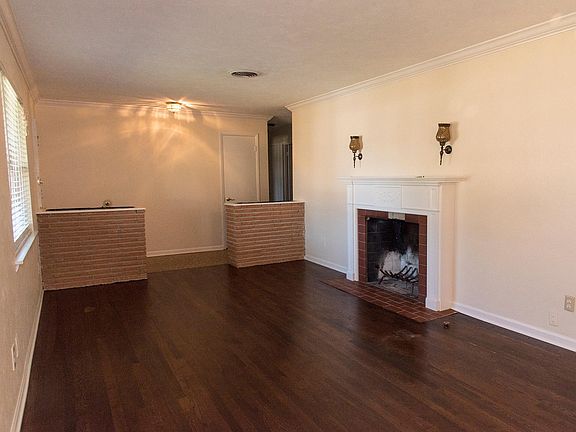 Open formals with original oak hardwoods, brick planters, and tiled entry.