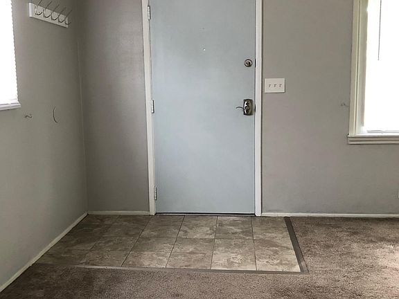 Freshly painted living room w/carpeting & new foyer tile.