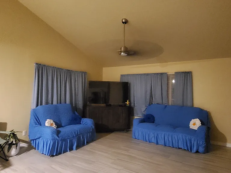Ample living room with protective covers. 
Automatic recliner sofa. 
Manual recliner Love-seat.
