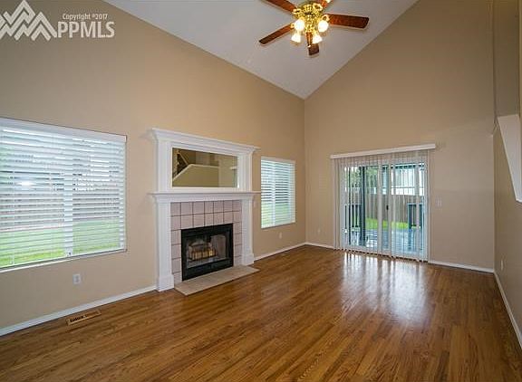 Living Room features wood burning fireplace, walk-out to deck, vaulted ceiling & ceiling fan.