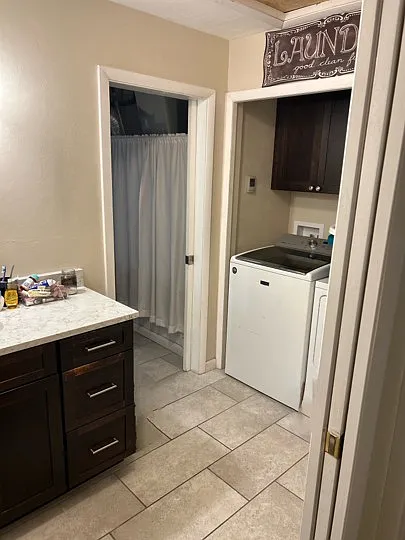 Bathroom #2/Laundry room: Bathroom in the rear of the home next to the 3rd downstairs bedroom and bonus room is divided into two sections. The first is the sink and laundry area. The pocket door leads to the "water closet" which has the toilet and shower.