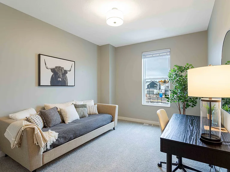 Inviting room with a cozy sofa and stylish decor, featuring a large window with a scenic view. Perfect for relaxing or working from home.