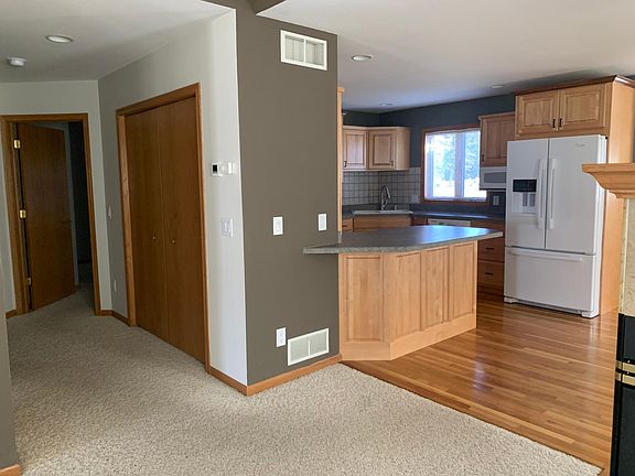Kitchen with hardwood floor. Hallway leads to first floor master suite, additional 1/2 bath, full basement, pantry, first floor laundry and mudroom.
