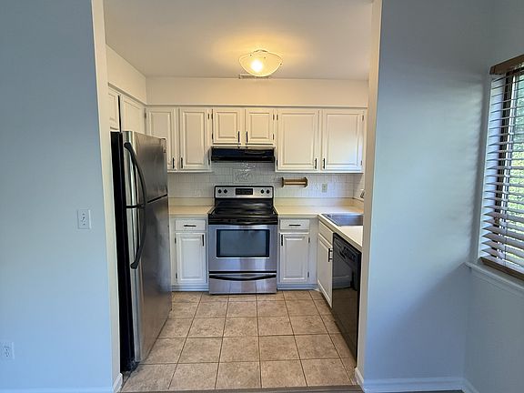 Kitchen with new appliances. (there is a window over the sink which you can see the woods. Pic is taken from sliding glass doors that access the deck.