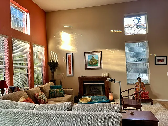 Cozy and comfortable living room with high ceilings and lots of light includes a gas burning fireplace.