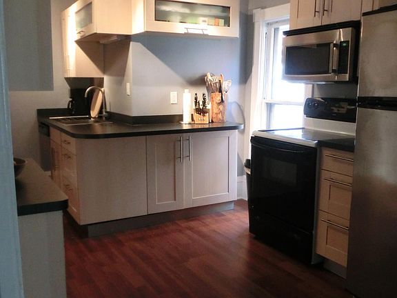 Stainless steel appliances and breakfast bar in large open modern kitchen