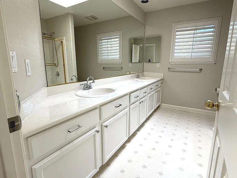 Upstairs Bathroom with a dual sink vanity and skylight