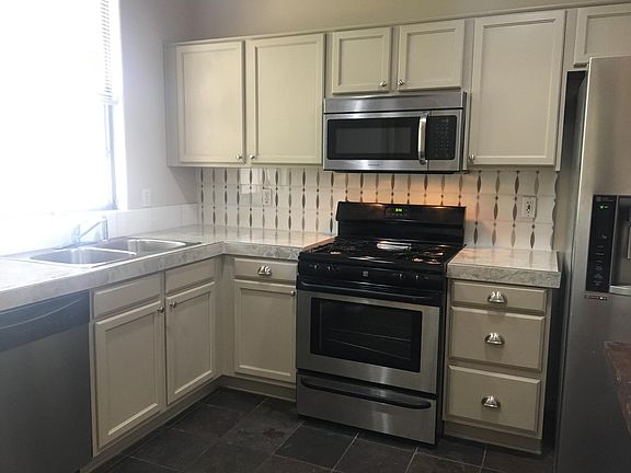 Freshly painted cabinets, new tile counters, marble backsplash, new hardware, stainless appliances