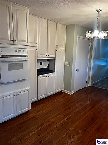 Kitchen with appliances, pantry, ample cabinet storage, and entry door from garage.