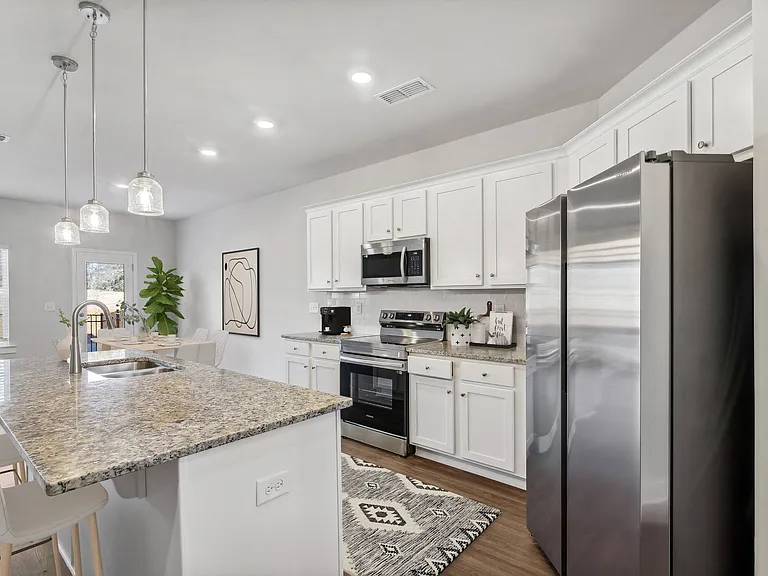 Spacious kitchen with an island, ample storage, stainless steel appliances and view into the backyard.