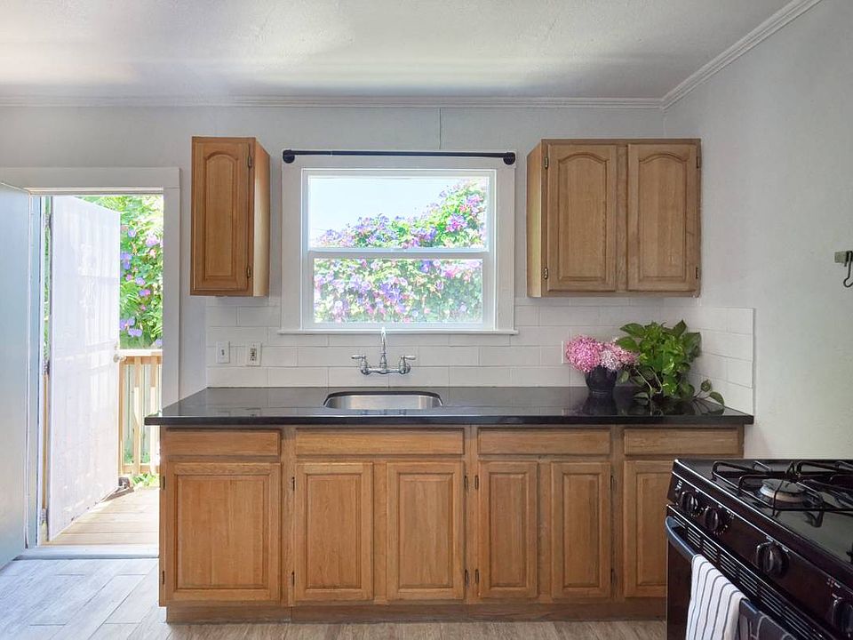 Kitchen and backdoor out to private garden and bistro table with chairs.