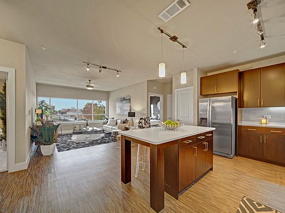 Open Concept Living with Kitchen Island, Stainless Appliances, and Built in Shelving